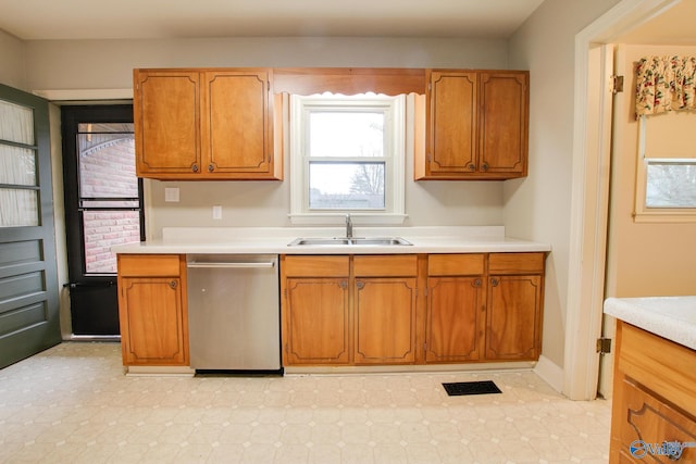 kitchen featuring light countertops, a sink, dishwasher, brown cabinets, and visible vents