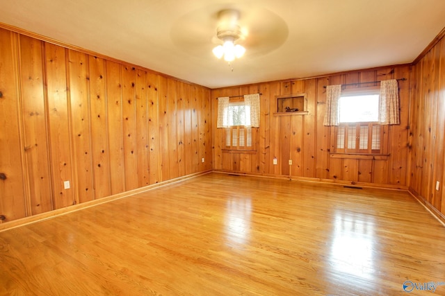 spare room with a ceiling fan, plenty of natural light, and light wood-type flooring