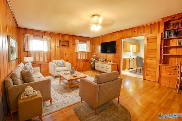 living area with plenty of natural light, light wood-style flooring, and a ceiling fan