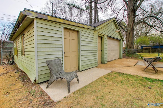 view of outbuilding featuring an outdoor structure, fence, and a garage