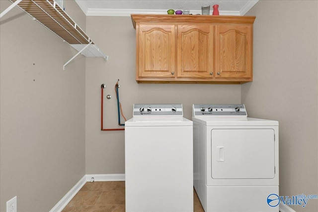 clothes washing area featuring washer and dryer, baseboards, cabinet space, and crown molding
