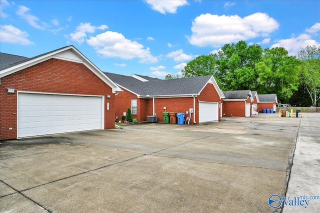 exterior space with brick siding, driveway, and a garage