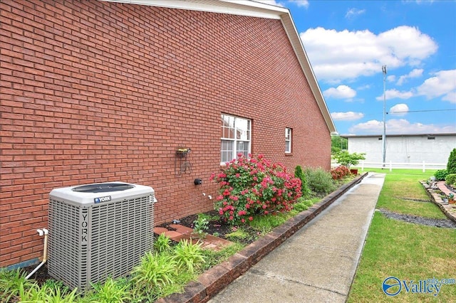 view of side of home with brick siding and central AC