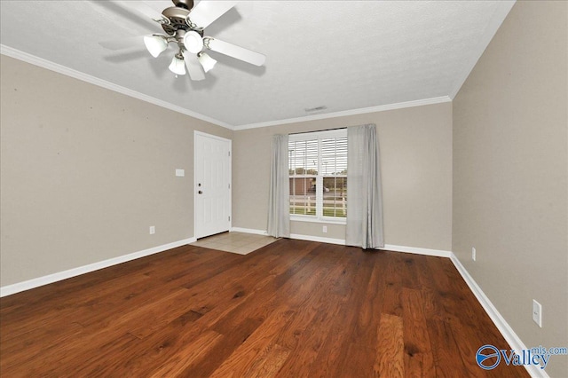 spare room with ceiling fan, baseboards, crown molding, and wood finished floors