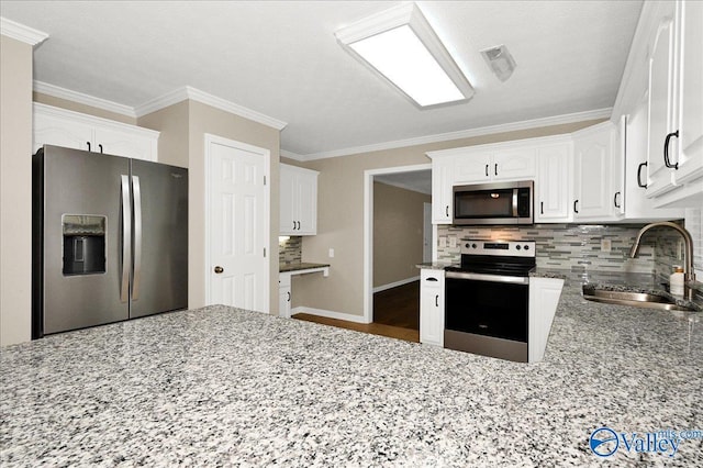 kitchen featuring white cabinets, stainless steel appliances, a sink, backsplash, and light stone counters