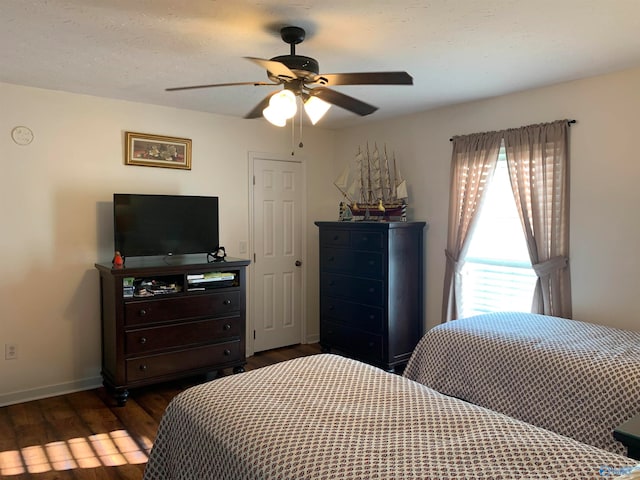 bedroom with ceiling fan and dark hardwood / wood-style flooring