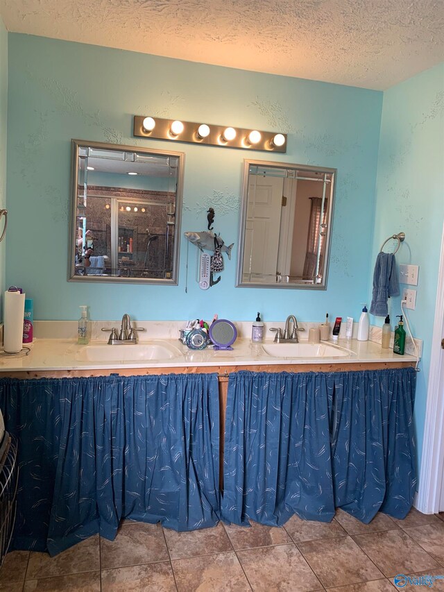 bathroom featuring tile patterned floors, vanity, and a textured ceiling