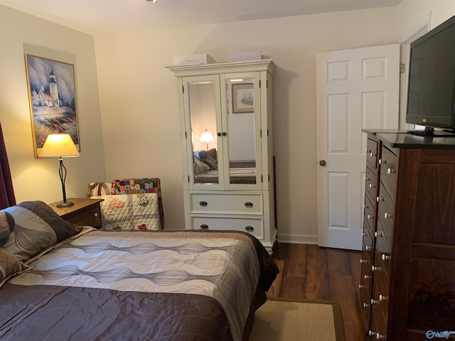 bedroom with dark hardwood / wood-style floors