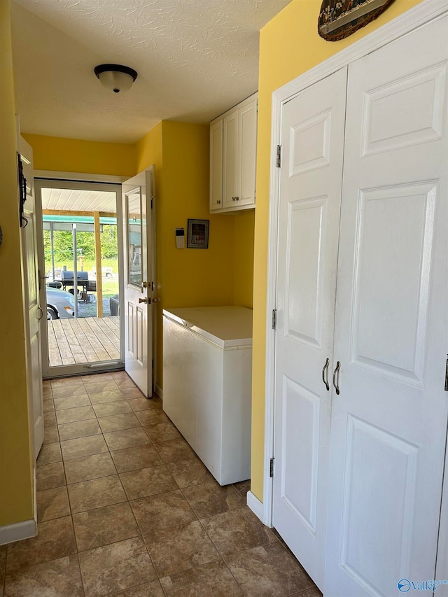 laundry room with cabinets and a textured ceiling