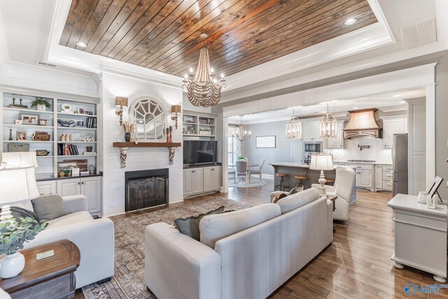 living room with a fireplace, a raised ceiling, wood-type flooring, and wood ceiling