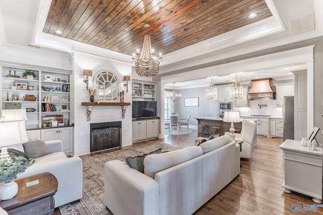 living room featuring wooden ceiling, a chandelier, and crown molding