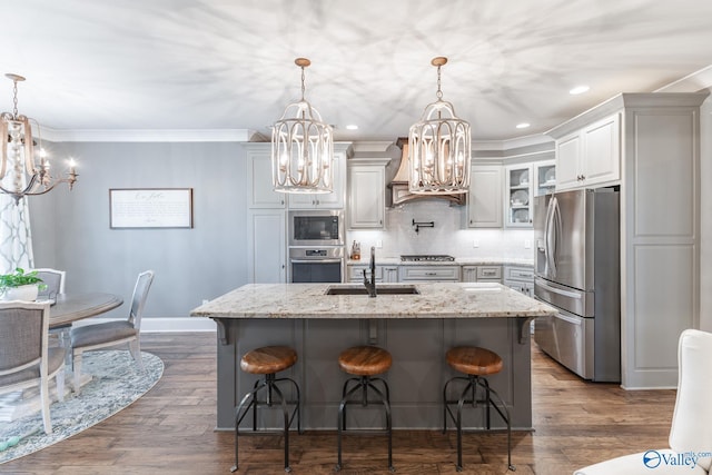 kitchen featuring a chandelier, hanging light fixtures, appliances with stainless steel finishes, and a kitchen island with sink