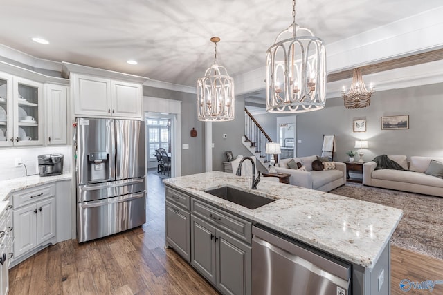 kitchen with dark wood-type flooring, an island with sink, white cabinetry, sink, and stainless steel appliances