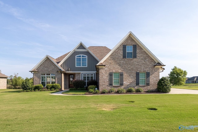 craftsman-style home with board and batten siding, a front yard, and brick siding