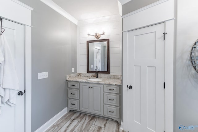 bathroom featuring wood finish floors, vanity, and baseboards