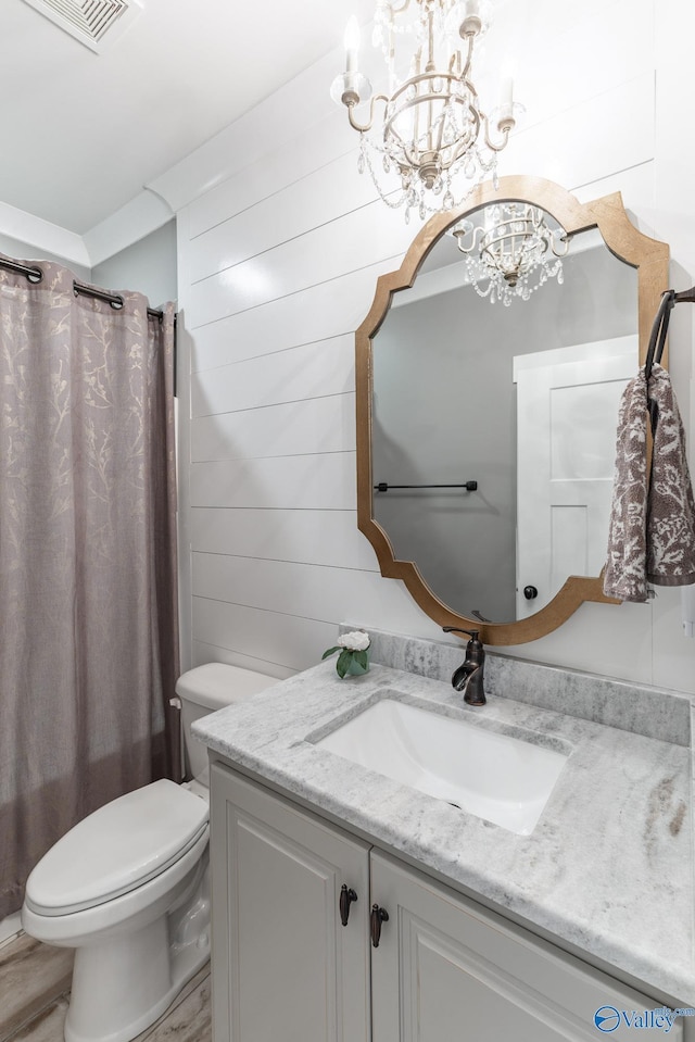 bathroom with wooden walls, visible vents, toilet, shower / tub combo with curtain, and vanity