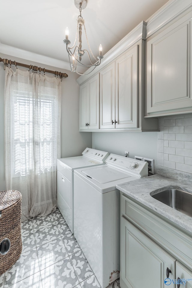 laundry room with washer and dryer, light tile patterned floors, a chandelier, and cabinets