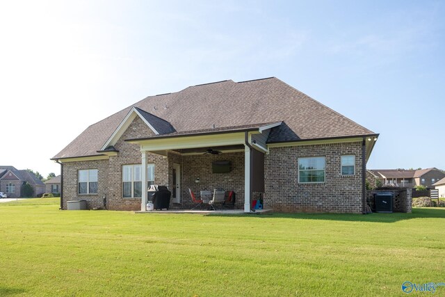 rear view of property featuring ceiling fan, a patio, and a yard