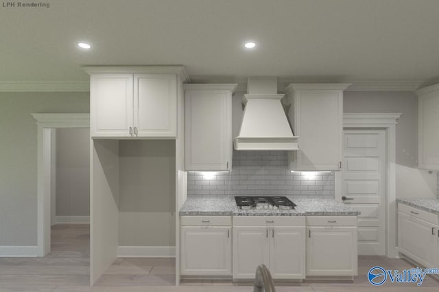 kitchen featuring white cabinetry, premium range hood, backsplash, light stone counters, and gas cooktop