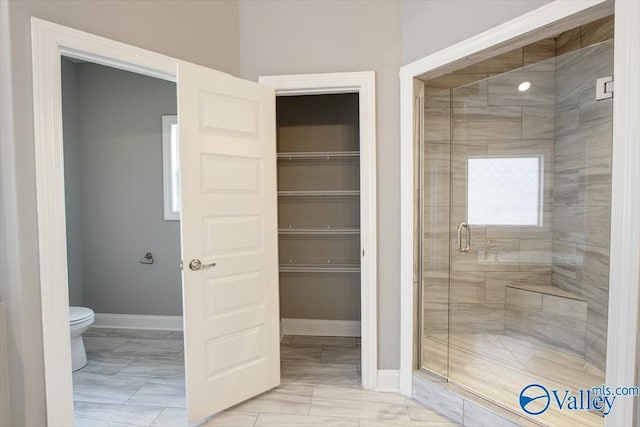 bathroom featuring toilet and walk in shower