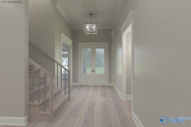 entryway featuring light hardwood / wood-style flooring, ornamental molding, and an inviting chandelier