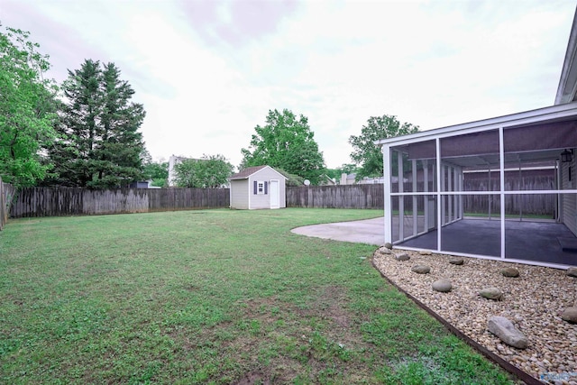 view of yard featuring a storage unit, a sunroom, a fenced backyard, and a patio