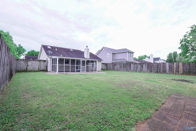 view of yard with a fenced backyard and a sunroom