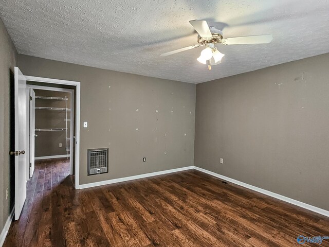 unfurnished bedroom featuring baseboards, dark wood finished floors, and heating unit