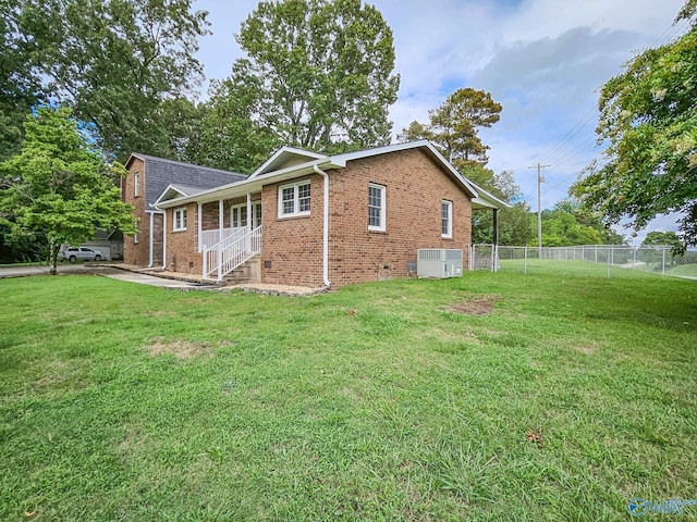 view of home's exterior with brick siding, fence, central AC unit, and a lawn