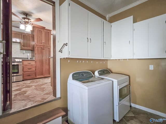 clothes washing area featuring washing machine and clothes dryer, cabinet space, ornamental molding, ceiling fan, and baseboards