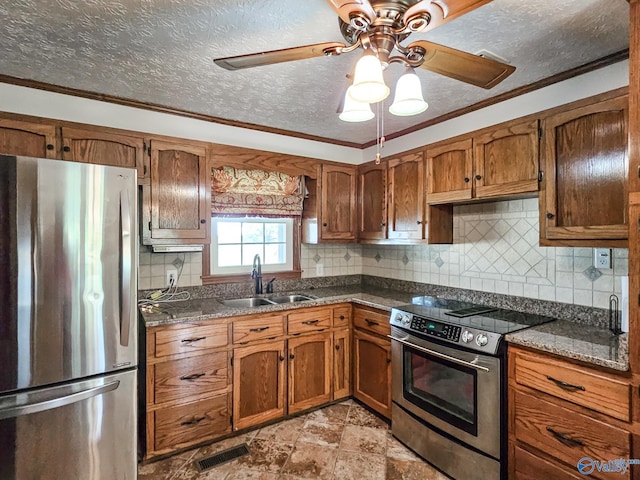 kitchen with visible vents, appliances with stainless steel finishes, brown cabinetry, and a sink