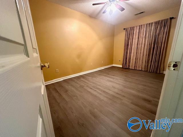 spare room featuring dark wood-type flooring and ceiling fan