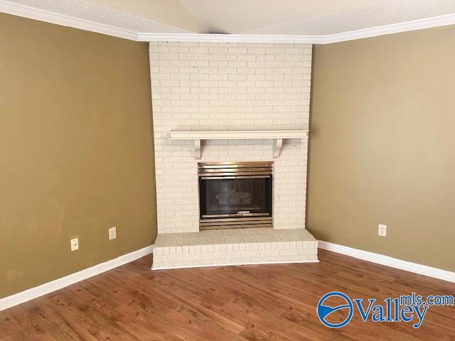 interior details with ornamental molding, hardwood / wood-style floors, and a brick fireplace