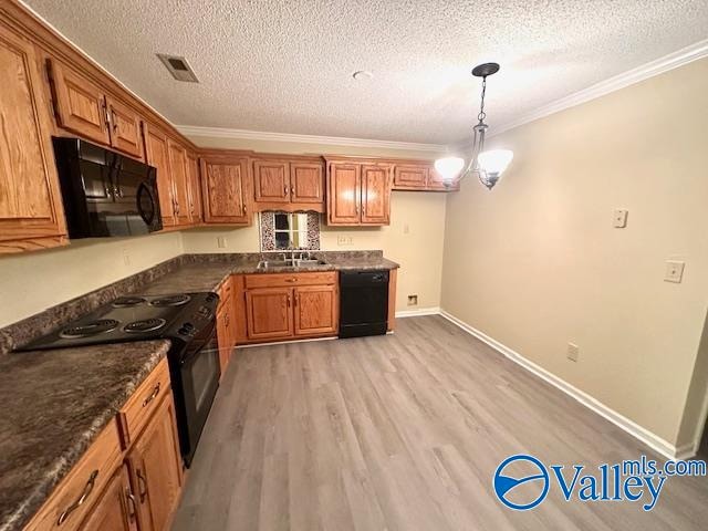kitchen featuring light hardwood / wood-style flooring, hanging light fixtures, sink, black appliances, and crown molding