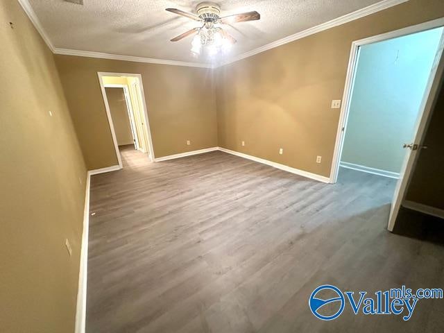 empty room featuring ornamental molding, a textured ceiling, hardwood / wood-style flooring, and ceiling fan