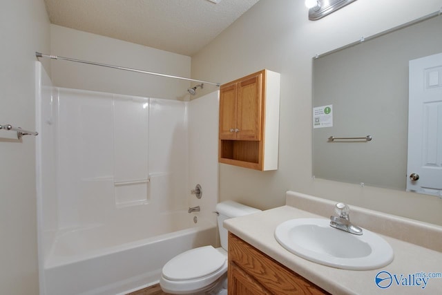 bathroom featuring toilet, vanity,  shower combination, and a textured ceiling