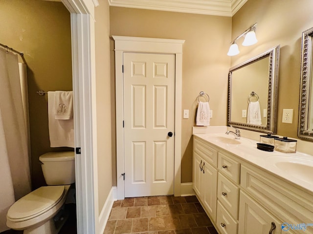 bathroom with toilet, vanity, and crown molding