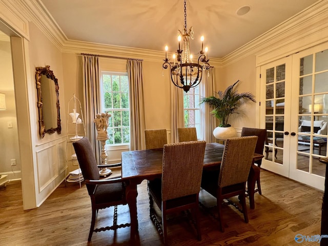 dining space featuring a chandelier, french doors, hardwood / wood-style flooring, and crown molding