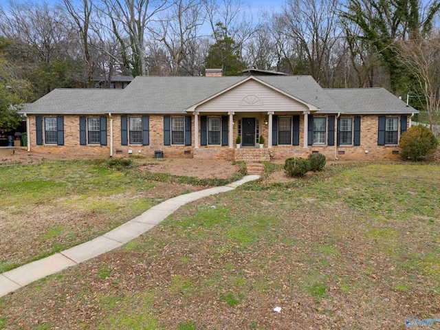 single story home featuring covered porch and a front yard