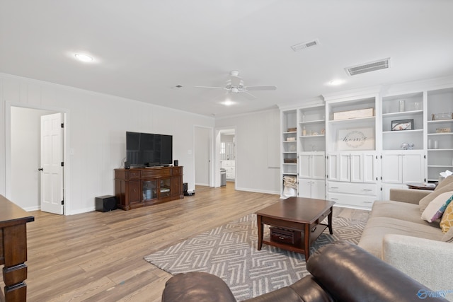 living room featuring light wood-type flooring, ceiling fan, and ornamental molding