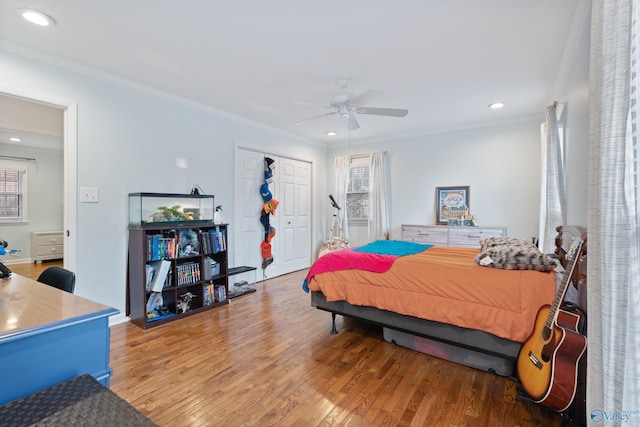 bedroom with multiple windows, ceiling fan, wood-type flooring, and ornamental molding