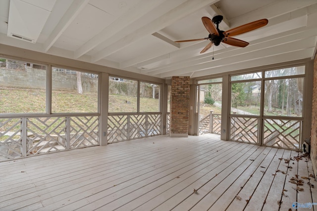 unfurnished sunroom featuring beamed ceiling and ceiling fan