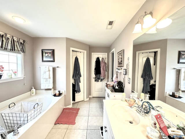 bathroom with a tub, tile patterned flooring, and vanity