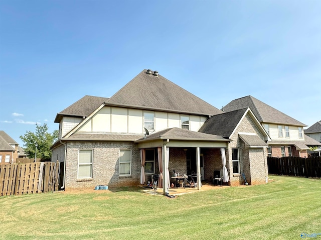 back of property with a lawn and a patio