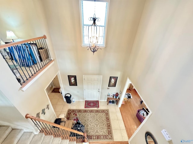 tiled foyer entrance with a towering ceiling and a notable chandelier