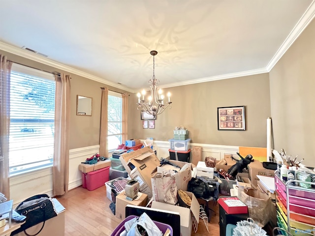 dining area with a notable chandelier, ornamental molding, and light hardwood / wood-style flooring