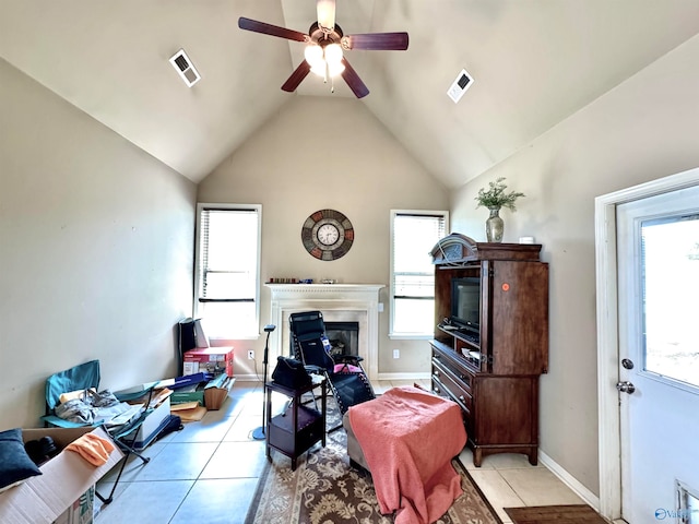 tiled living room featuring high vaulted ceiling, ceiling fan, and a healthy amount of sunlight