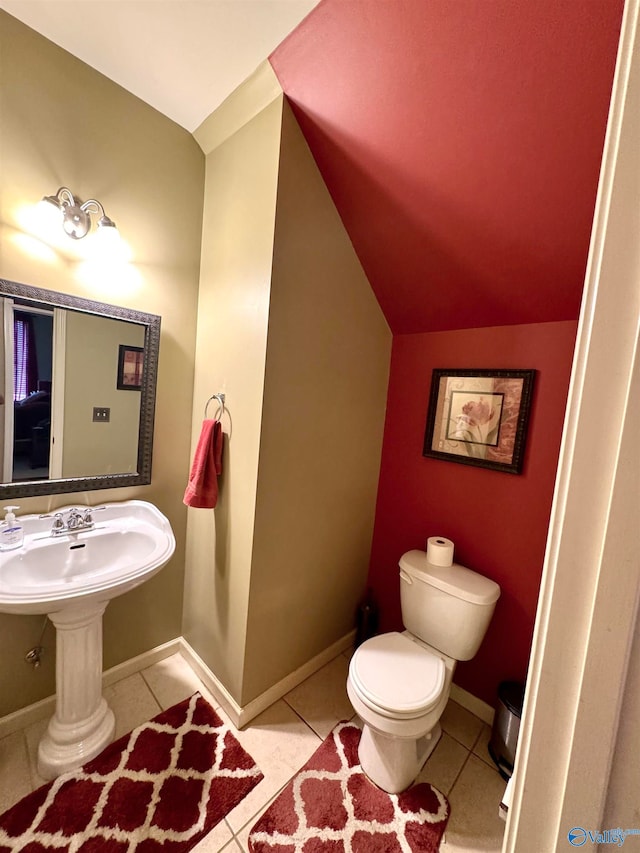 bathroom with tile patterned flooring, lofted ceiling, and toilet