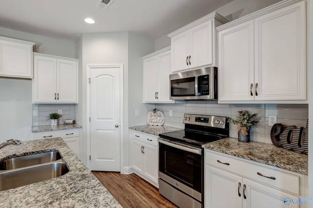 104 Pointe Haven Ct, Huntsville, AL 35824 - kitchen with appliances with stainless steel finishes, dark wood-type flooring, a sink, white cabinetry, and decorative backsplash