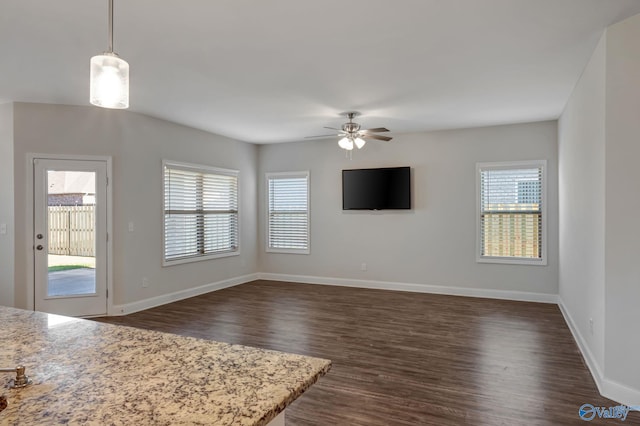 unfurnished living room with ceiling fan and dark hardwood / wood-style floors